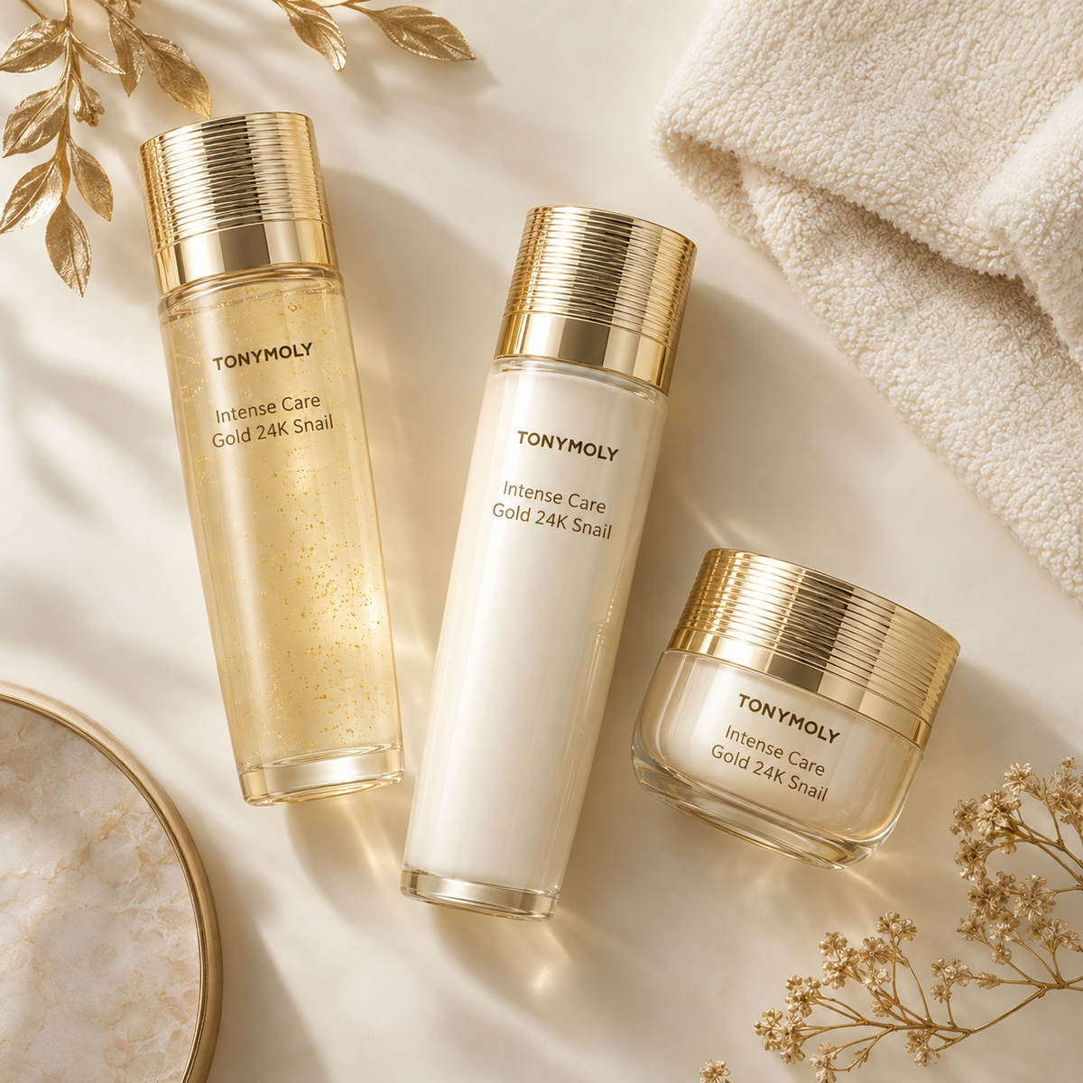 TONYMOLY Intense Care Gold 24K Snail toner, emulsion and cream set styled on an ivory vanity
